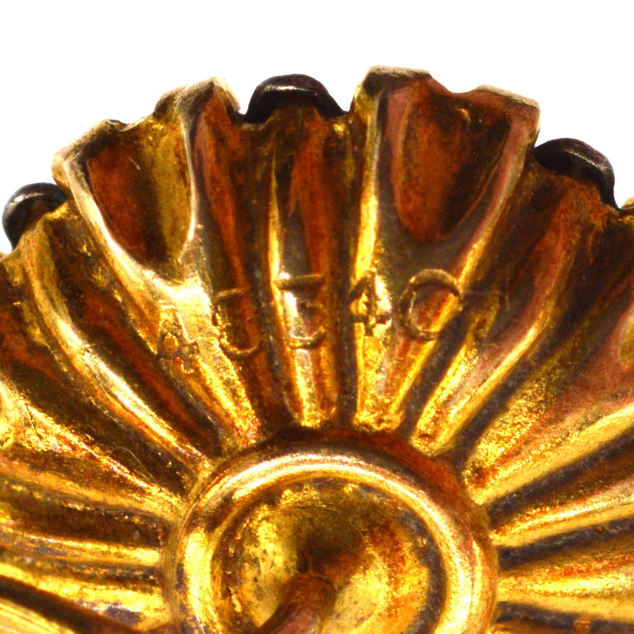 Close-up of the intricate design and detailing of a vintage gold earring, showcasing its craftsmanship.