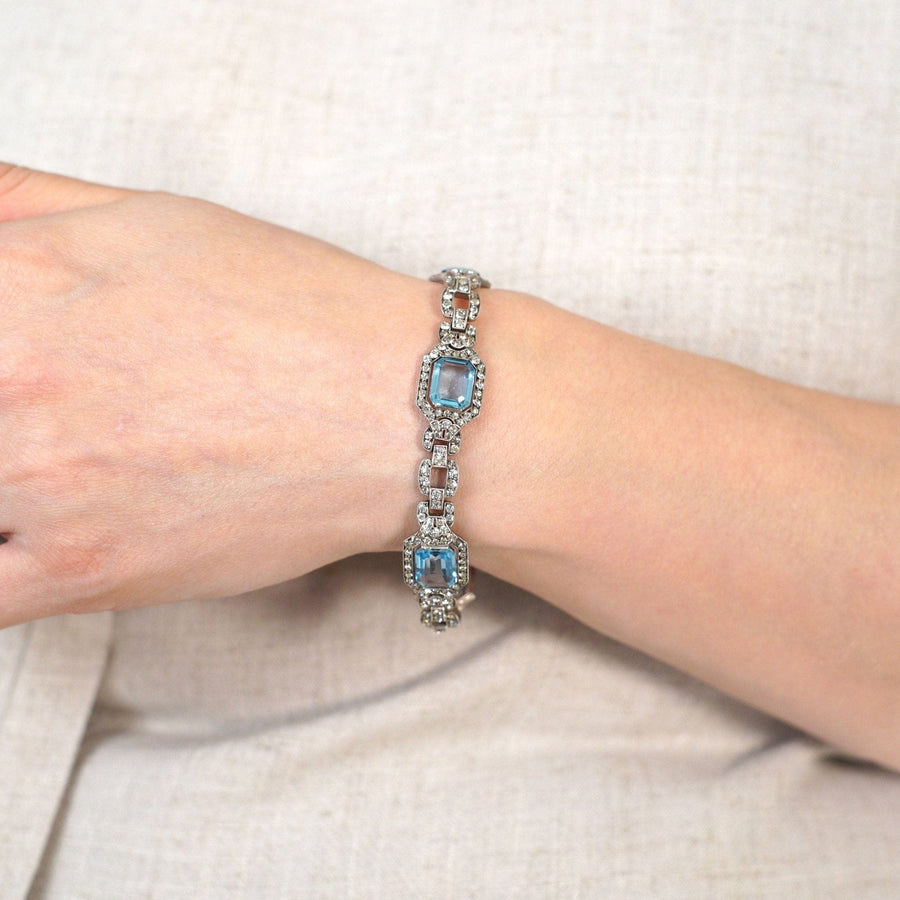 Art Deco silver bracelet featuring blue and white paste stones, showcasing a vintage design on a woman's wrist.