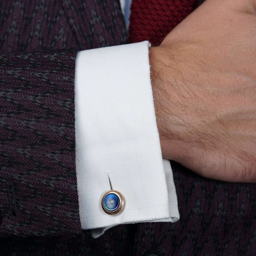 Close-up of a man's cuff with an Art Deco silver gilt cufflink featuring black mother-of-pearl and a paste diamond.