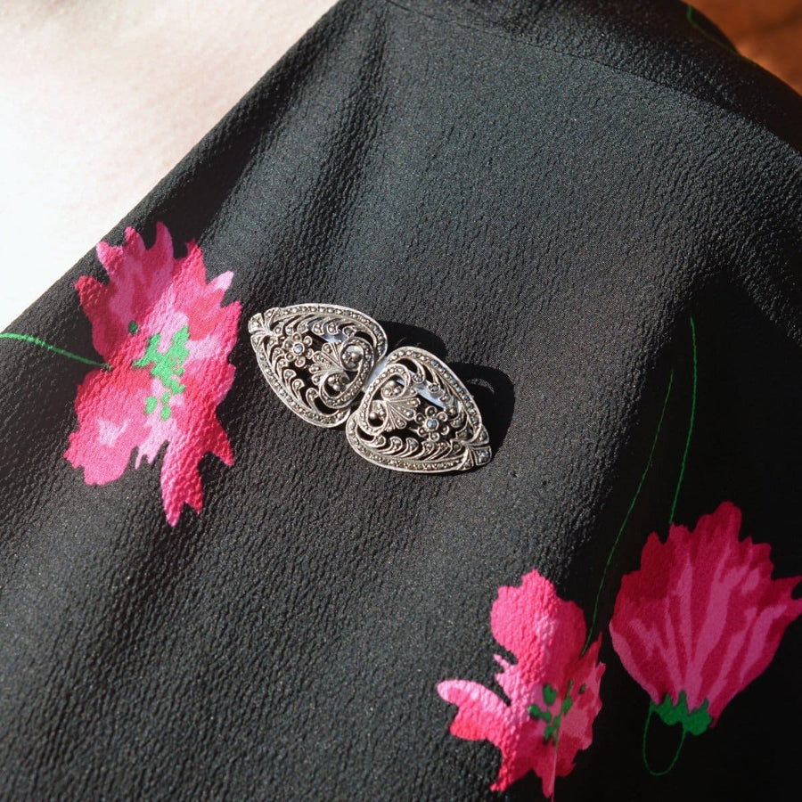 Art Deco silver & marcasite double clip brooch on a black floral top, showcasing vintage elegance from the 1920s.