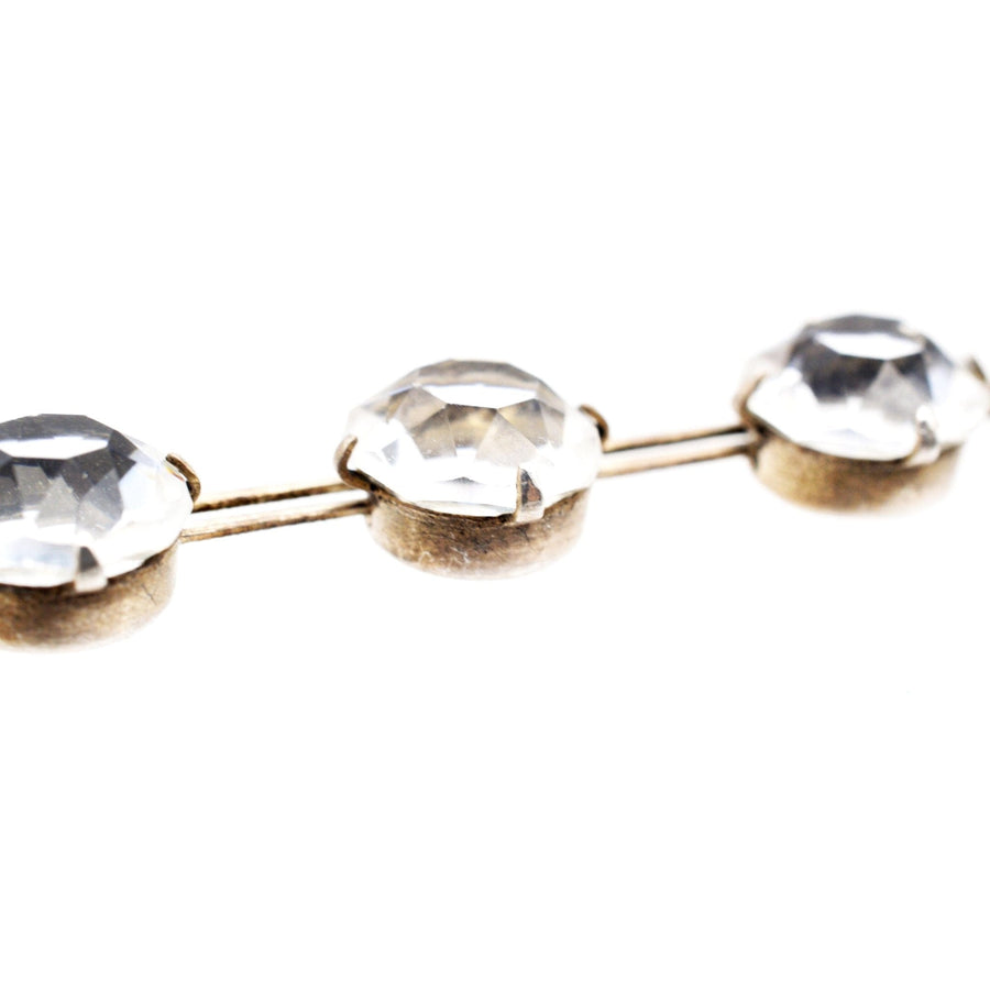 Close-up of an antique silver necklace featuring lustrous white stones set in a classic riviere design.