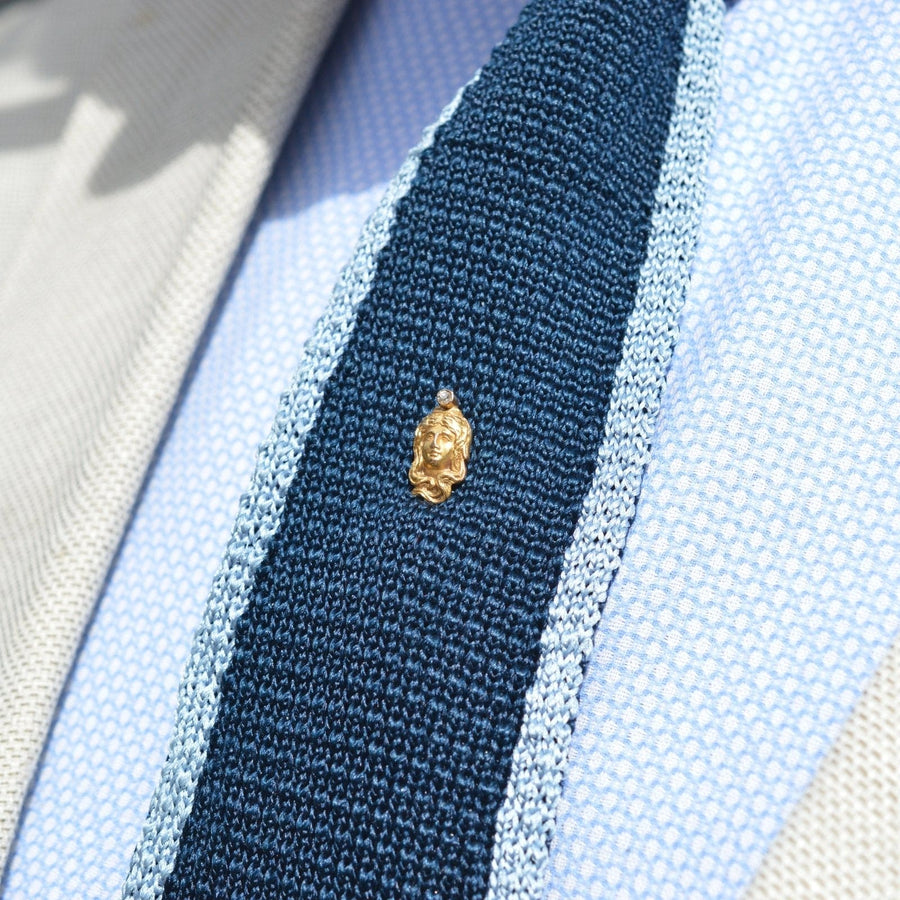 Art Nouveau 15ct gold lady portrait pin on a stylish blue tie, showcasing elegant vintage jewelry.