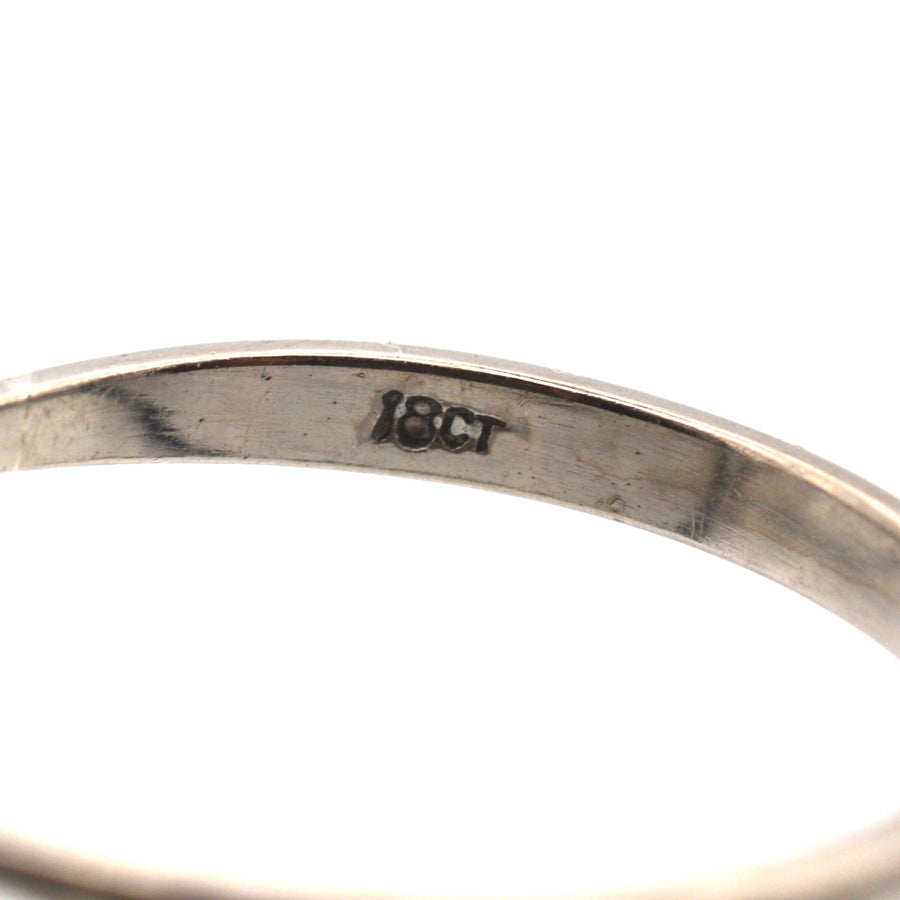 Close-up of the inner band showing the '18ct' stamp on a vintage diamond ring.