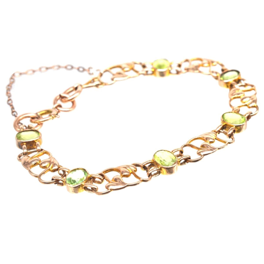 Art Nouveau 9ct gold bracelet featuring a stylized leaf design and six peridot gemstones, dating back to the 1910s.