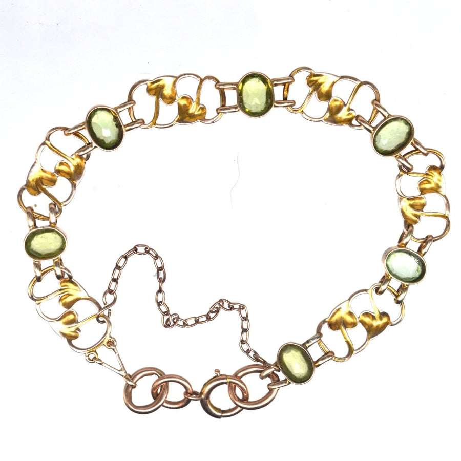 Art Nouveau 9ct gold bracelet featuring elegant peridots in a stylized leaf pattern, dating back to the 1910s.