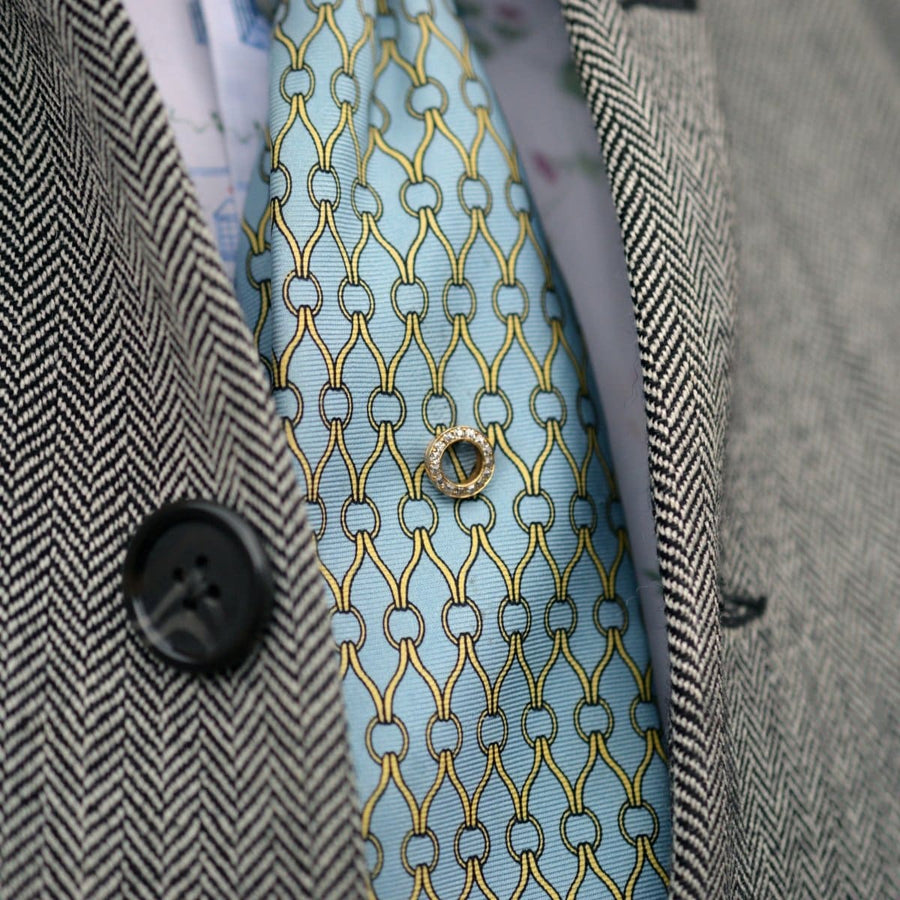 Austro-Hungarian 14ct gold and diamond tie pin on a blue patterned silk tie and herringbone blazer.