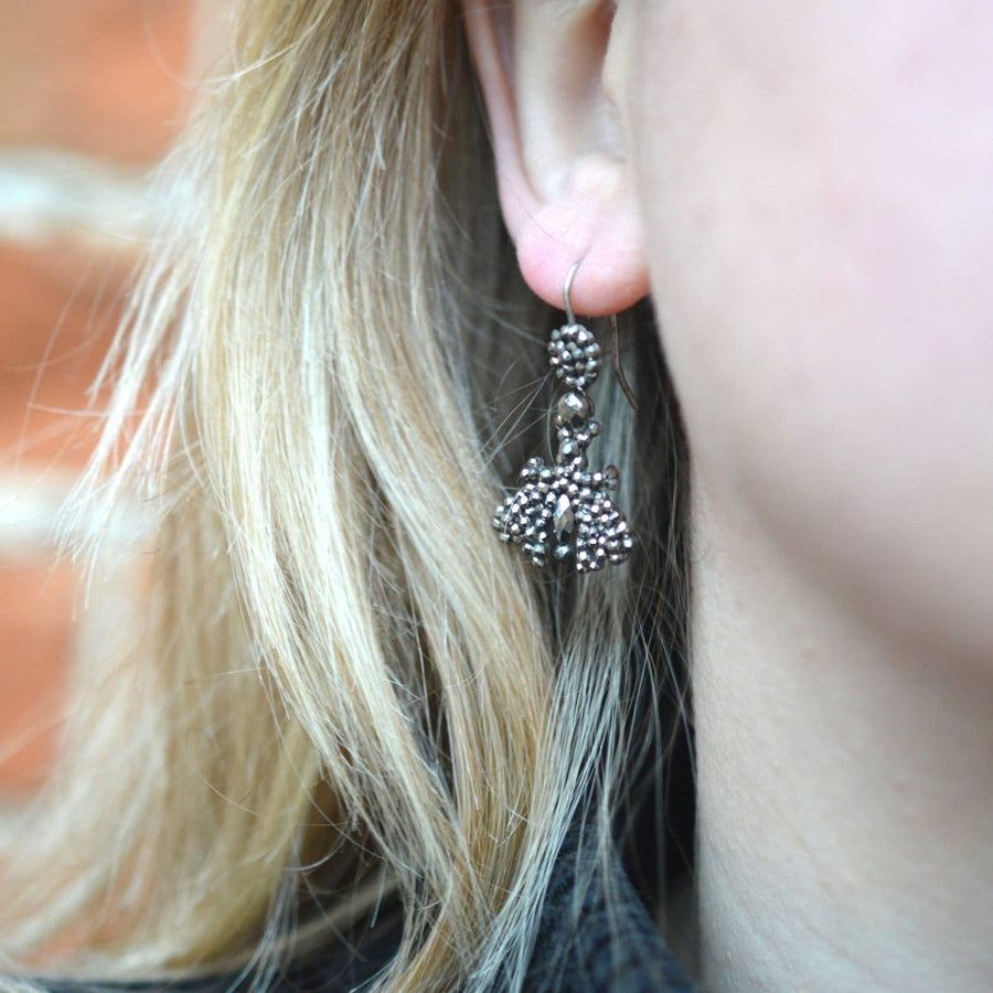 Early 19th century cut steel butterfly earrings sparkling in natural light, showcasing intricate craftsmanship.
