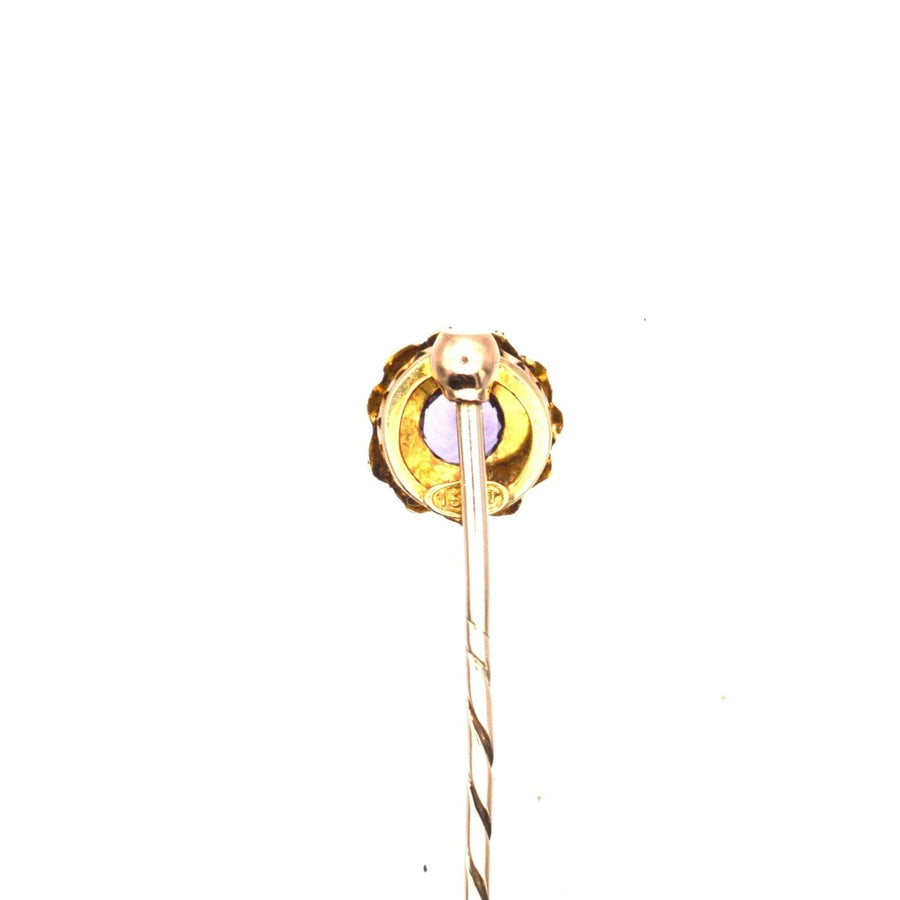 Edwardian 15ct gold stickpin featuring an amethyst and pearl cluster with intricate design.