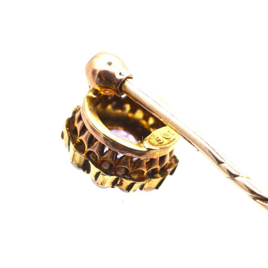 Close-up of an Edwardian gold stickpin featuring an amethyst and pearl cluster with intricate detailing.