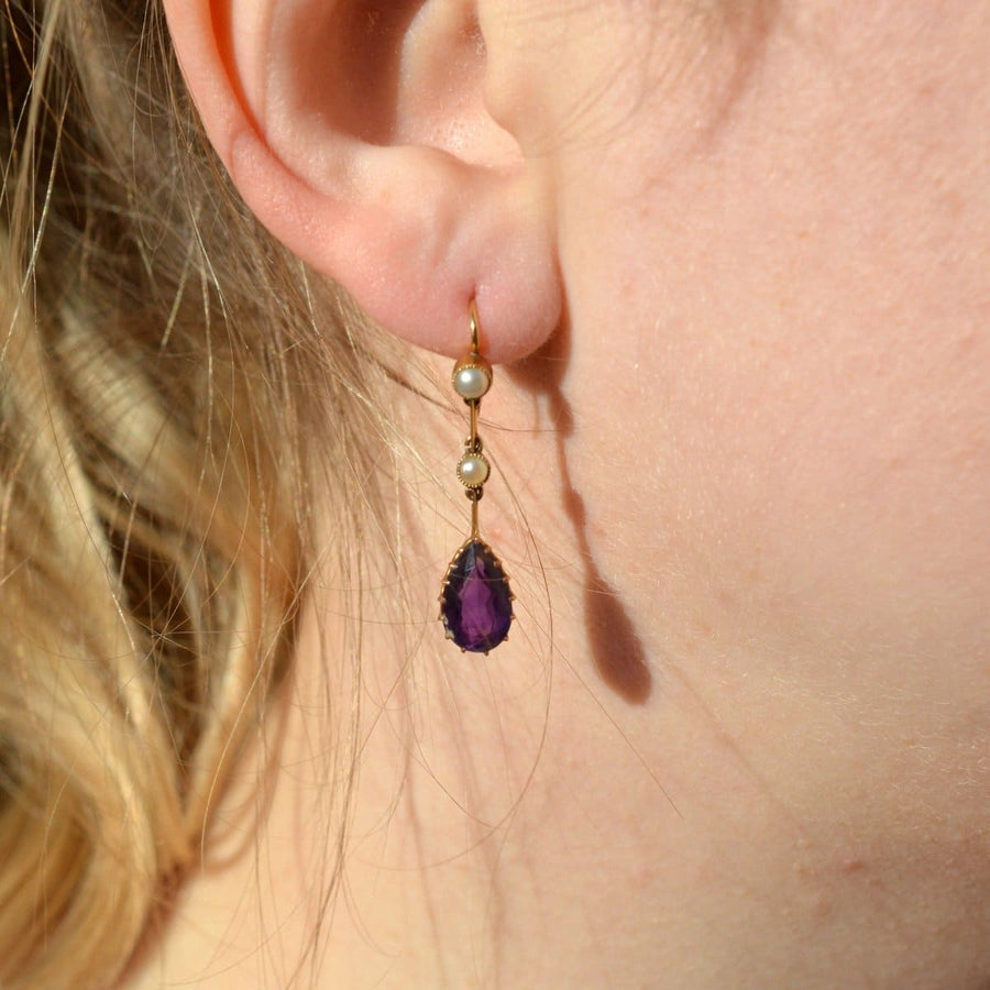 Edwardian 15ct gold drop earrings featuring pear-shaped amethyst and split pearls, elegantly hanging from gold links.