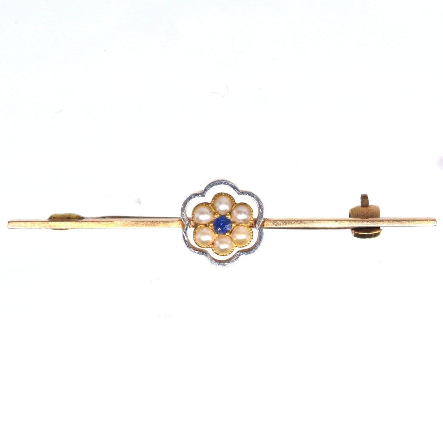 Edwardian 15ct gold and platinum bar brooch featuring a sapphire and pearl cluster flower design.