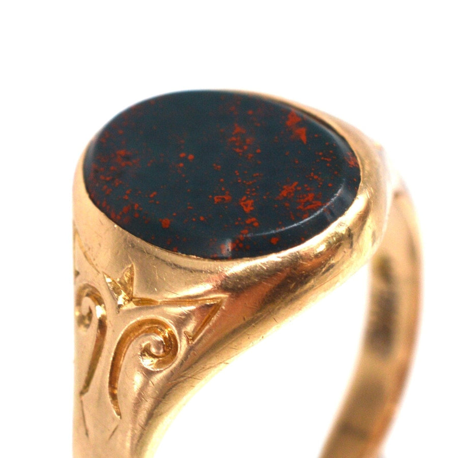 Edwardian 15ct gold signet ring featuring bloodstone, elegant design with intricate detailing.