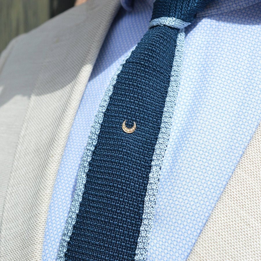 Edwardian 15ct gold Cheshire moon tie pin featuring split pearls on a blue tie in a stylish ensemble.