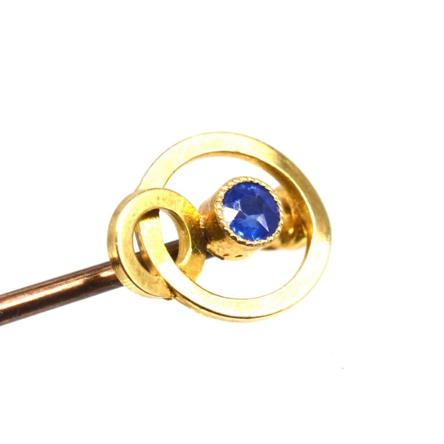 Edwardian 15ct gold double circle tie pin featuring a blue sapphire, elegant accessory for lapel or cravat.
