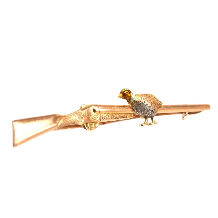 Edwardian 15ct Gold, Enamel & Platinum brooch featuring a grouse perched on a shotgun.