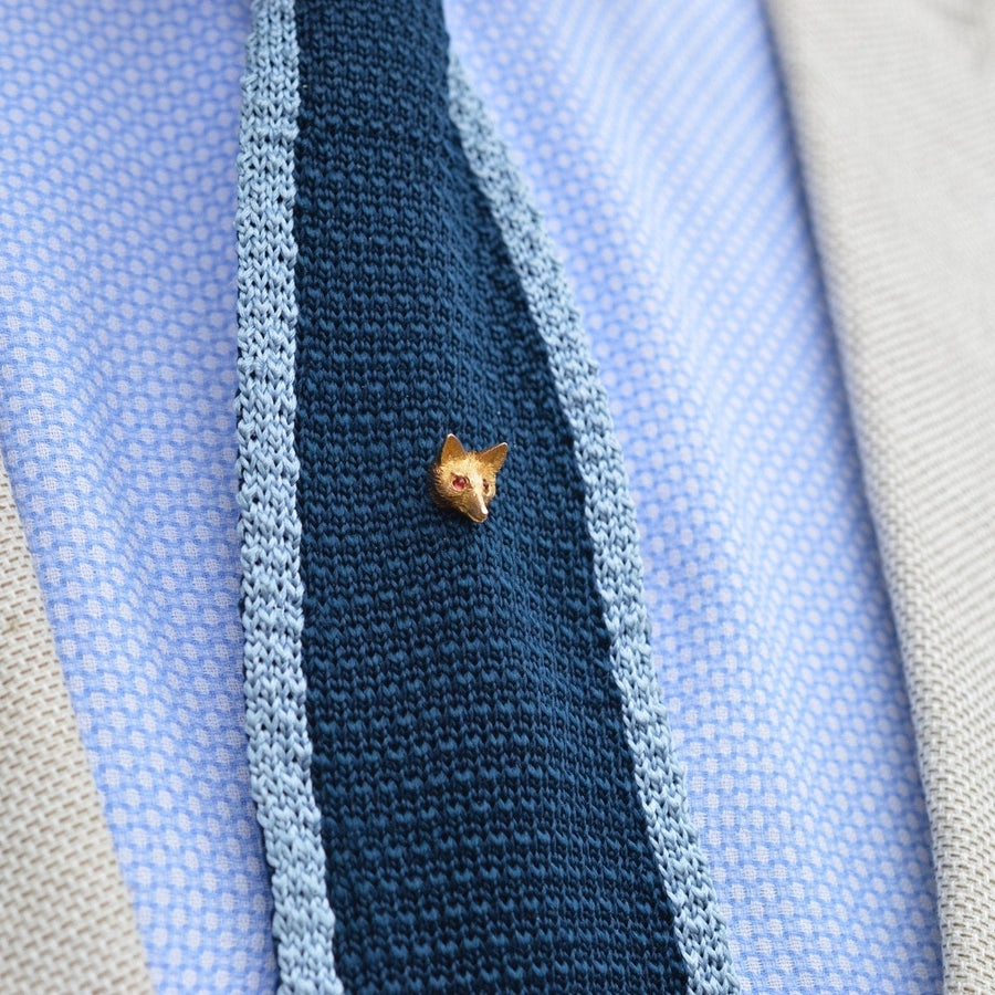 Elegant Edwardian 15ct gold fox tie pin with garnet red eyes, showcased on a blue knitted tie.