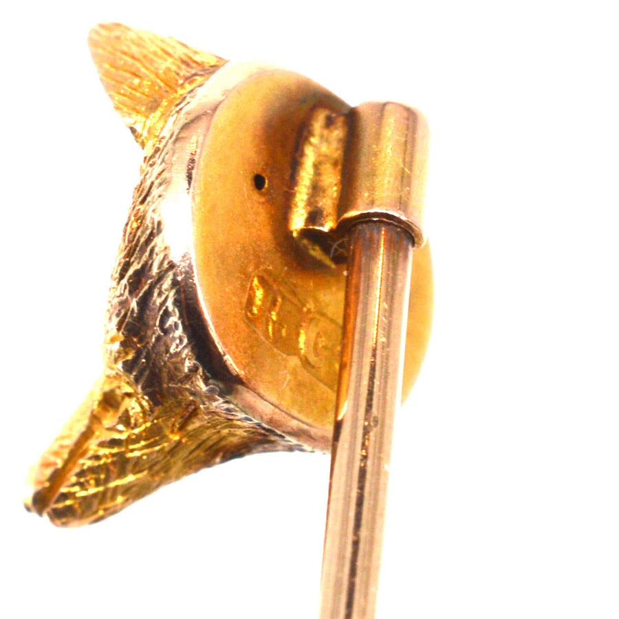 Close-up of an Edwardian 15ct gold fox tie pin with garnet red eyes, ideal for silk ties and lapels.