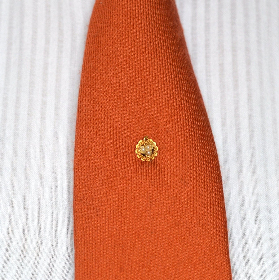 15ct gold lucky three leaf clover pearl tie pin displayed on an orange tie, symbolizing faith, hope, and love.