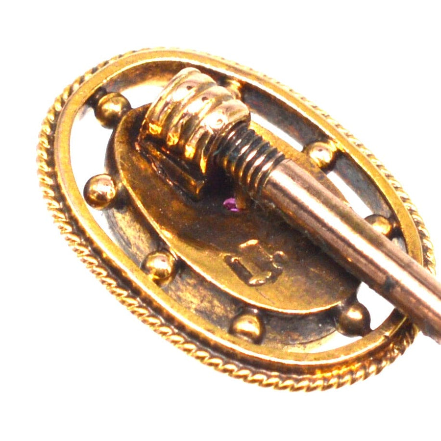 Close-up of Edwardian 15ct gold oval ruby star tie pin with gold rope-work frame and stopper.