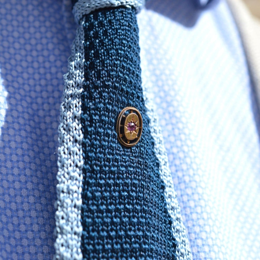 Close-up of Edwardian 15ct Gold Oval Ruby Star Tie Pin on a textured tie, ideal for enhancing formal attire.