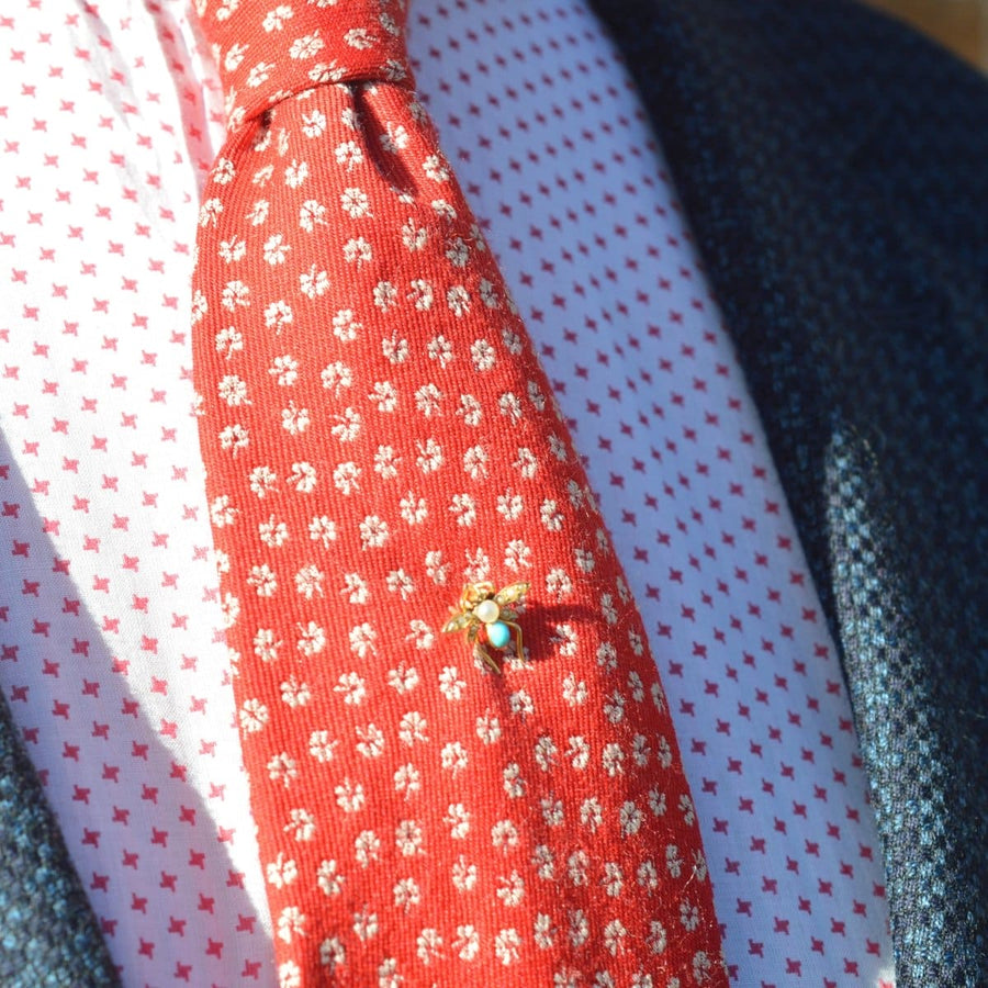 Edwardian 15ct gold bug tie pin with pearl and turquoise on a patterned red silk tie.