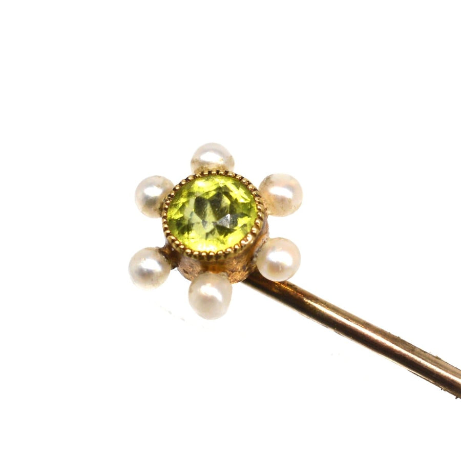 Edwardian 15ct gold tie pin featuring a vibrant peridot surrounded by pearls, a classic vintage accessory.