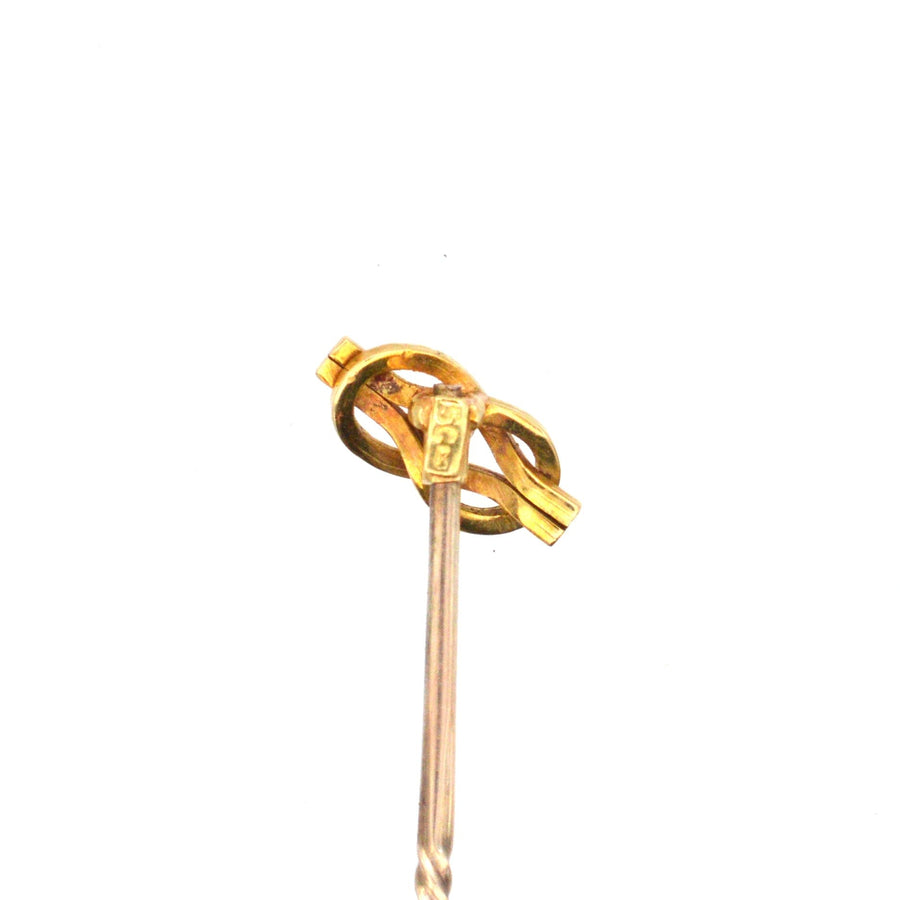 Edwardian 15ct gold reef knot tie pin with diamond, symbolizing love and unity, circa 1900.