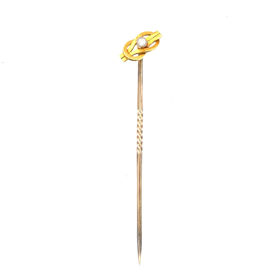 Edwardian 15ct gold reef knot tie pin featuring a diamond, symbolizing love and friendship, crafted circa 1900.