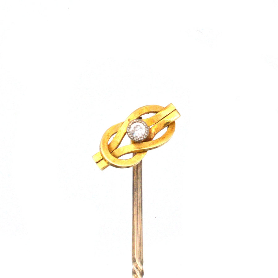 Edwardian 15ct gold reef knot tie pin with diamond centerpiece, symbolizing infinite love and friendship.