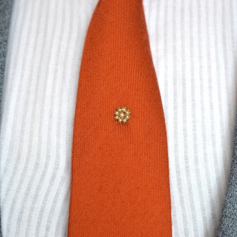 Edwardian 15ct gold split pearl flower tie pin on an orange tie, perfect for lapel or hat wear.