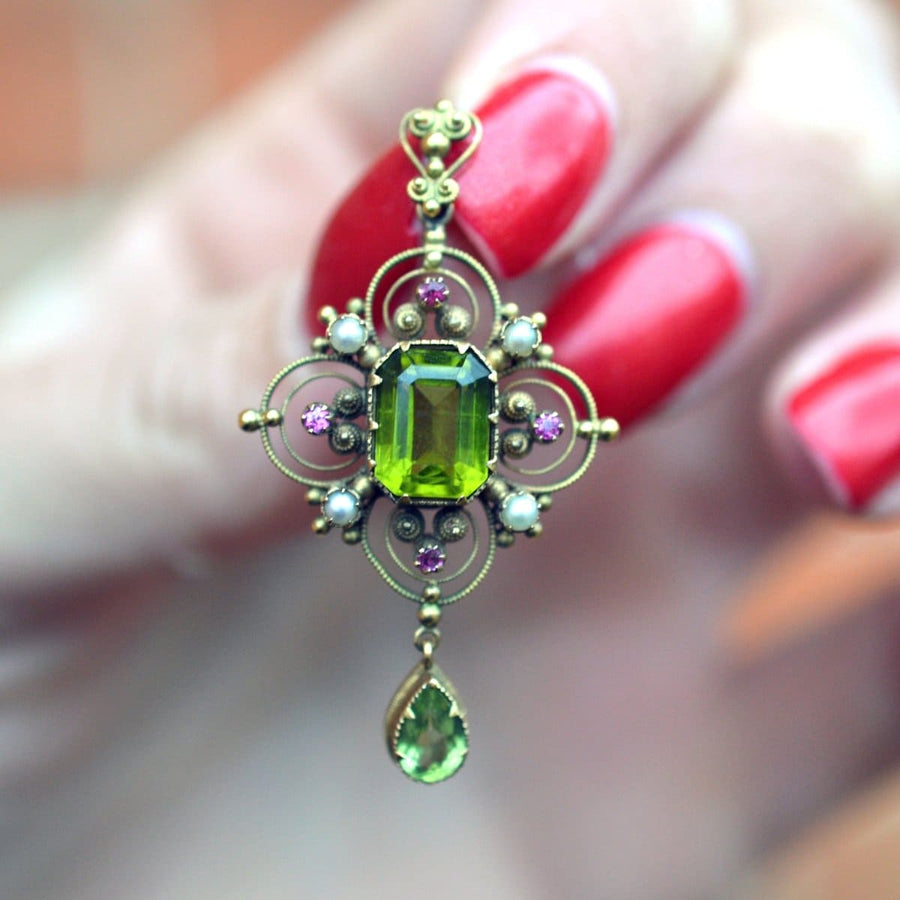 15ct gold Suffragette pendant featuring peridot, pearls, and rubies, showcasing exquisite Arts and Crafts design.