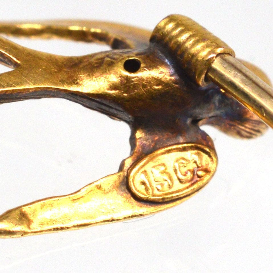 Close-up of a 15ct gold swallow bird tie pin, showcasing intricate detailing and hallmark.
