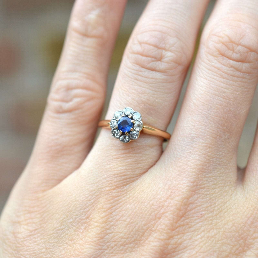Edwardian 18ct gold ring featuring a Ceylon sapphire and diamond cluster, showcased on a hand.
