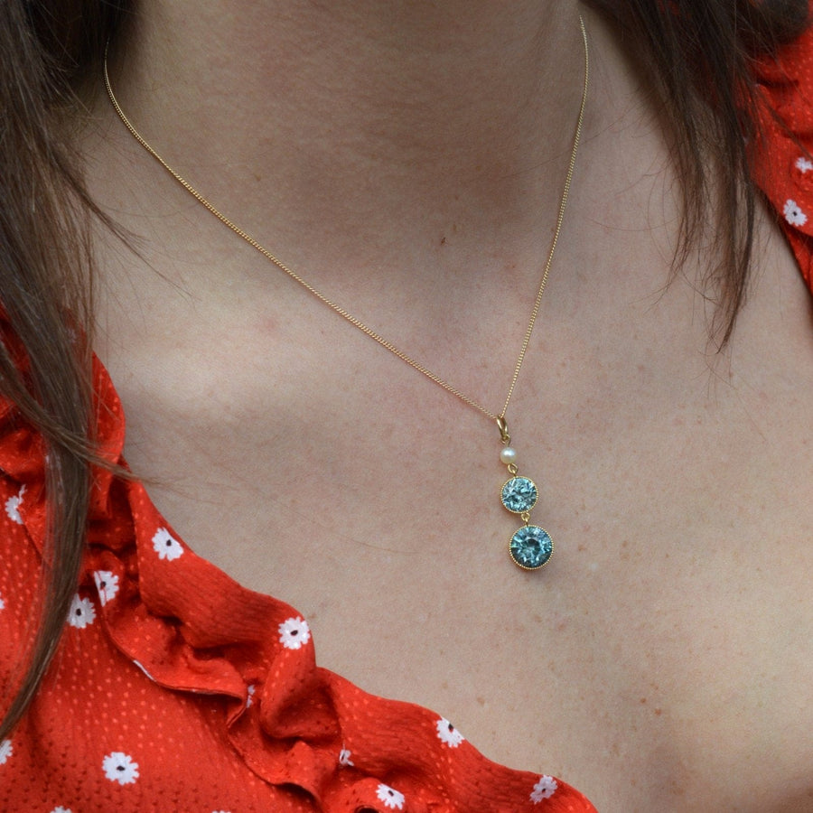 Edwardian 18ct gold blue zircon drop pendant with pearl on 9ct gold chain worn by model.
