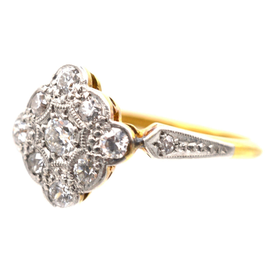 Edwardian 18ct gold and platinum diamond cluster ring with elegant shoulder design and diamond-shaped centerpiece.