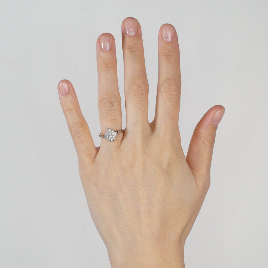 Elegant Edwardian diamond-shaped diamond cluster ring worn on a hand, showcasing its intricate design and shine.