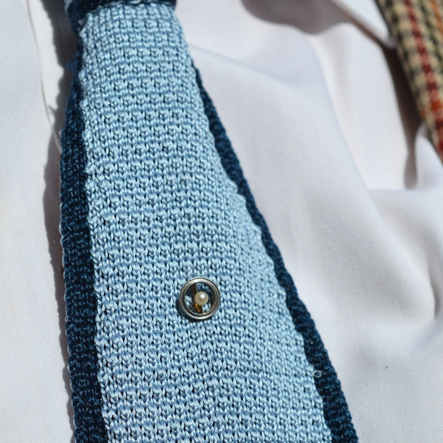 Edwardian round circle tie pin with pearl on a blue textured tie, perfect for formal occasions.