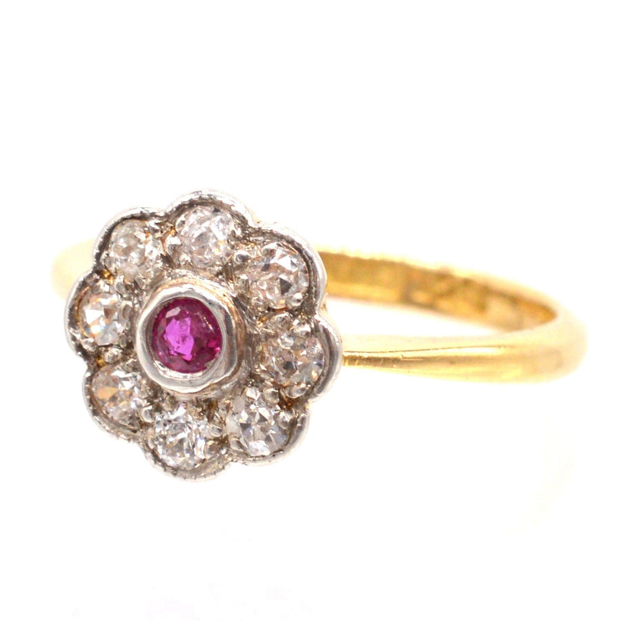 Edwardian 18ct gold and platinum cluster ring featuring a central ruby surrounded by sparkling diamonds.