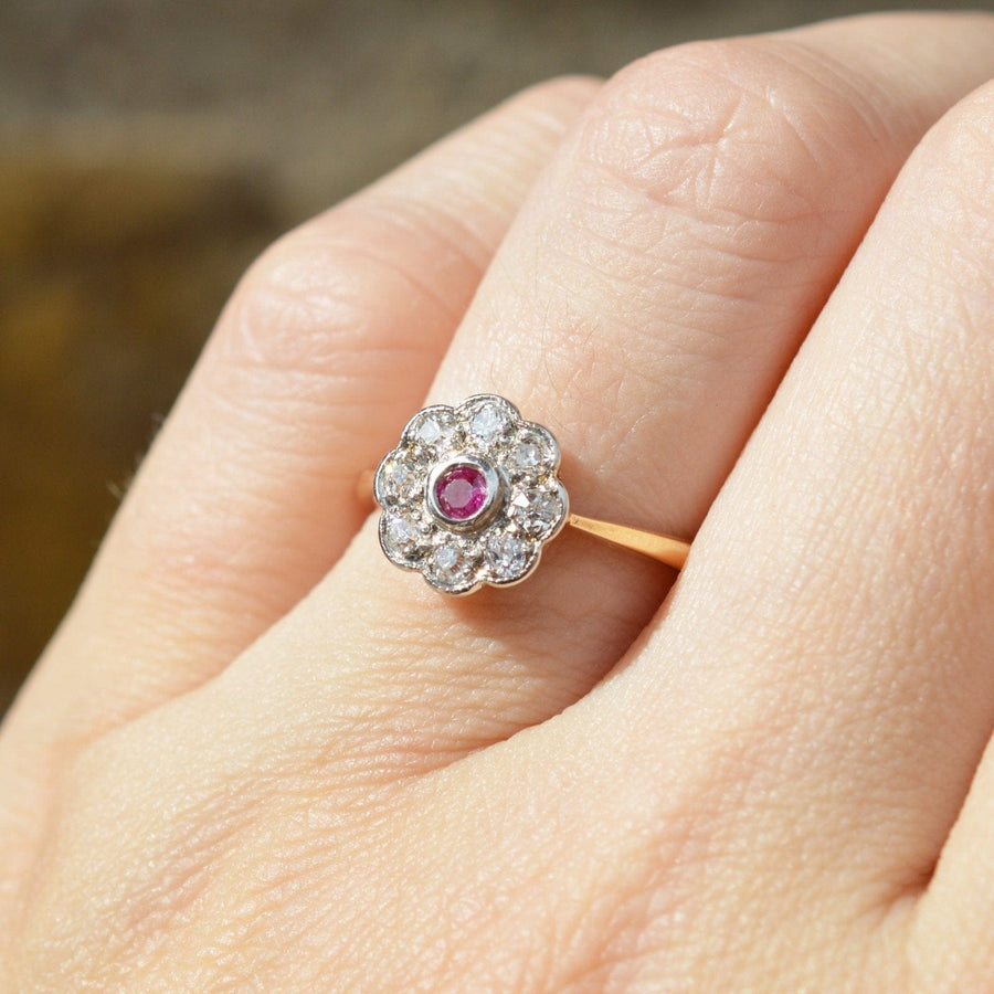 Edwardian 18ct gold and platinum ruby diamond cluster ring, featuring a central ruby and surrounded by sparkling diamonds.