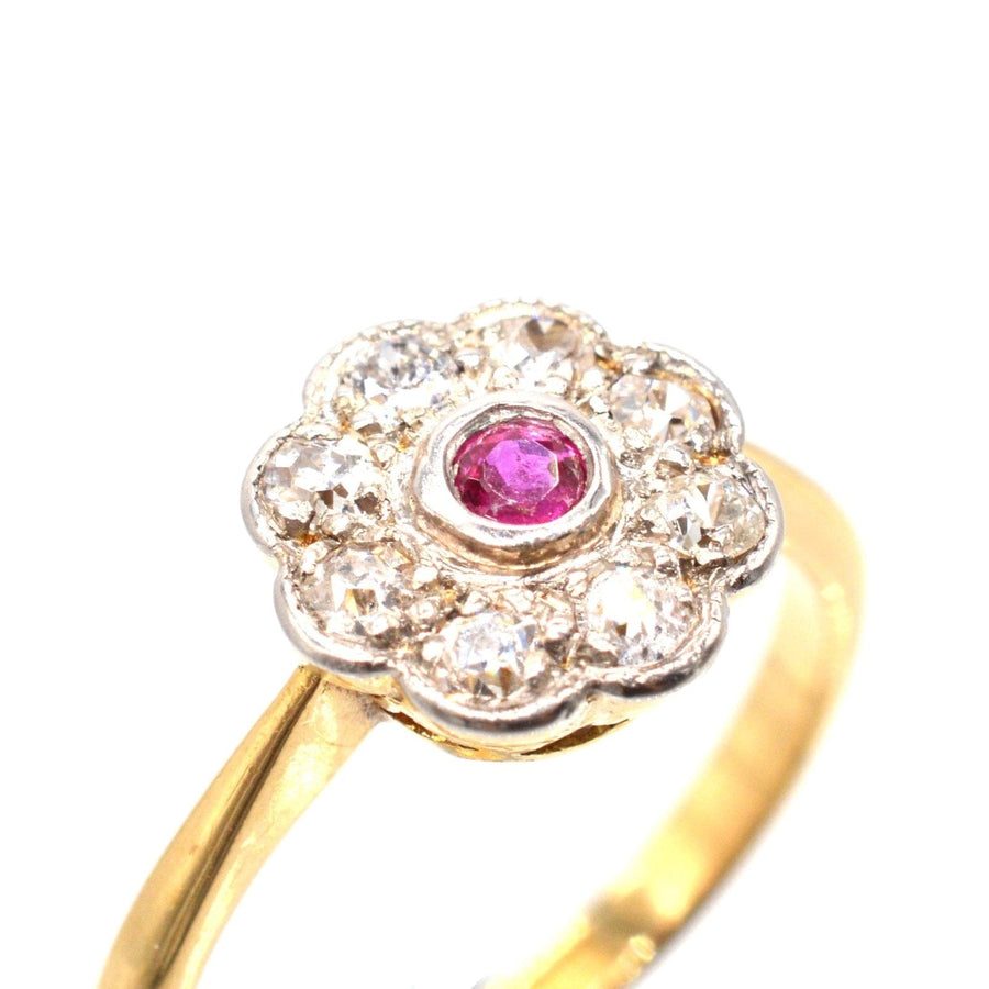 Edwardian 18ct gold and platinum ruby and diamond cluster ring featuring a central ruby and eight diamonds.