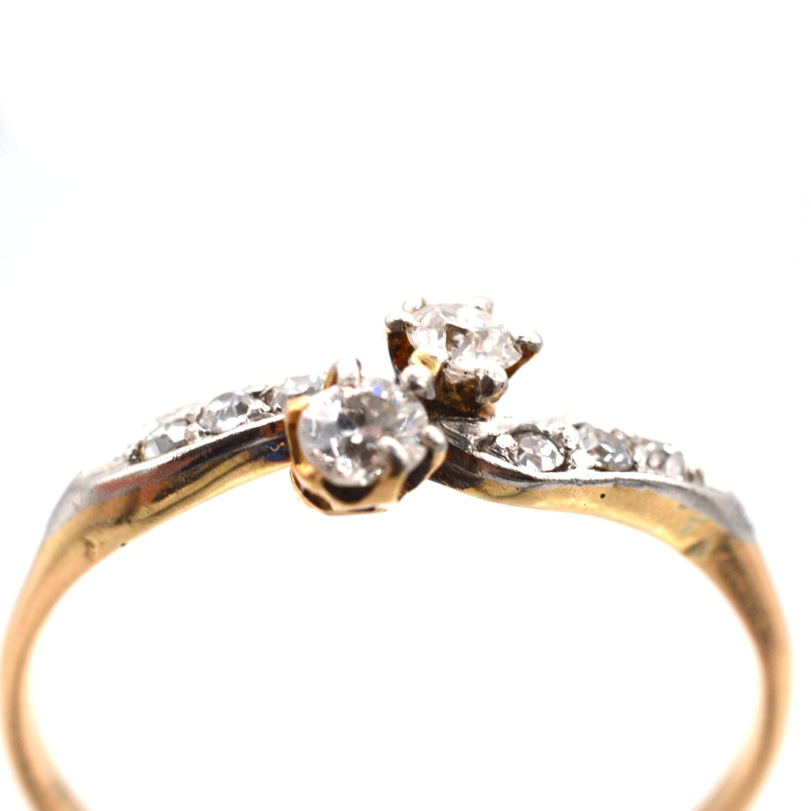 Edwardian 18ct gold and platinum diamond crossover ring with two stones and diamond shoulders.