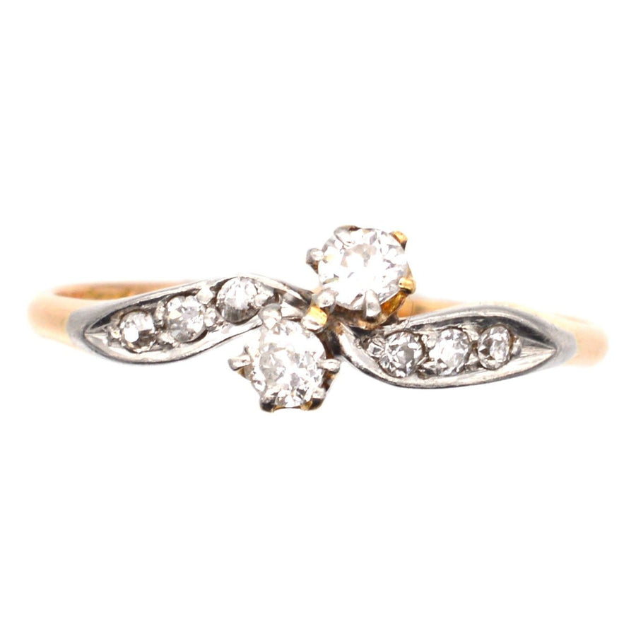 Edwardian 18ct gold and platinum crossover ring with two diamonds and diamond shoulders, ideal for engagements.