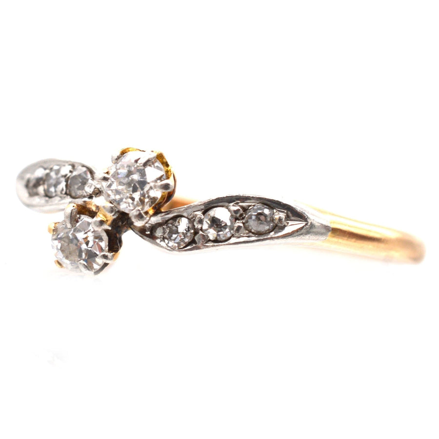 Edwardian two stone diamond crossover ring in 18ct gold and platinum with diamond shoulders.