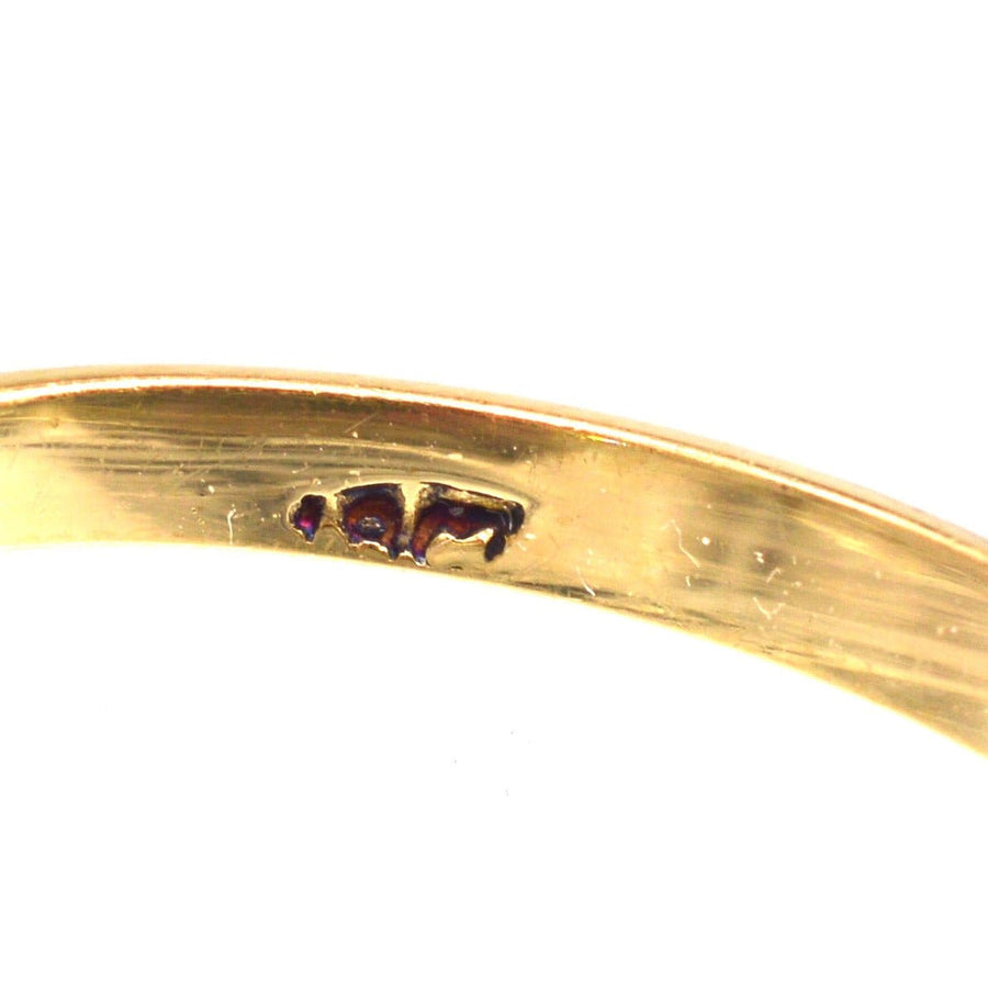 Close-up of the hallmark on an Edwardian 18ct gold ring, showcasing fine craftsmanship and detailing.