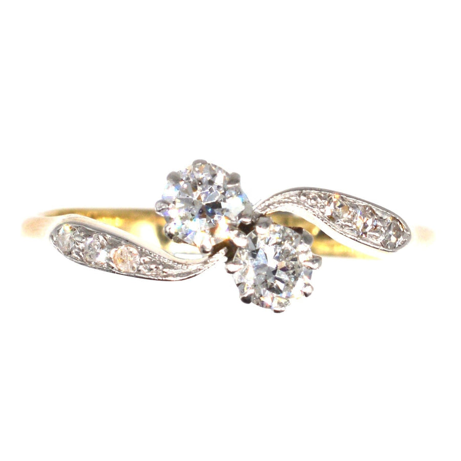 Edwardian 18ct gold and platinum Toi et Moi crossover ring with two diamonds and diamond shoulders.
