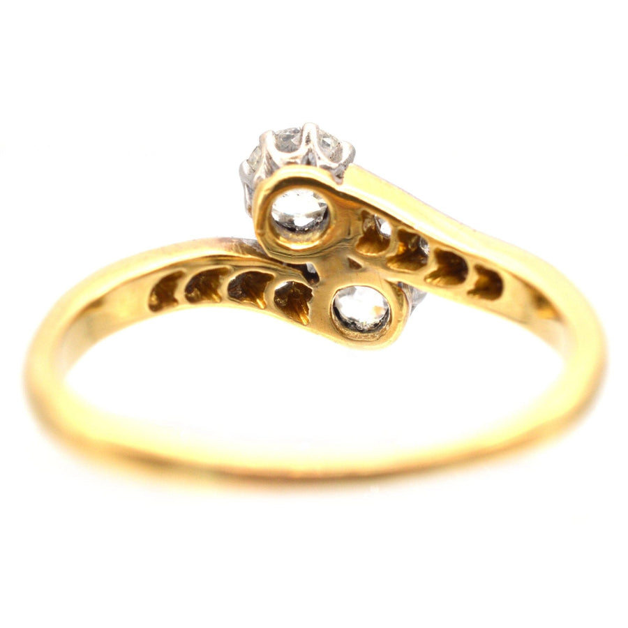 Edwardian 18ct gold and platinum two stone diamond Toi et Moi crossover ring with elegant design.