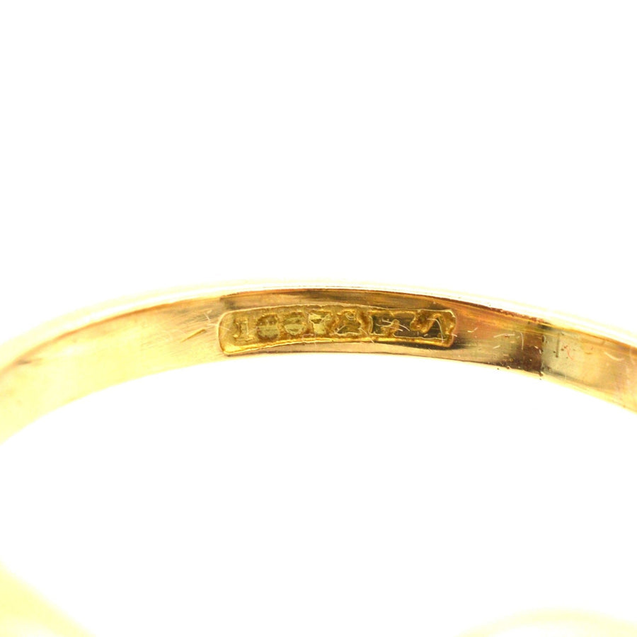 Close-up of the inside hallmark of an Edwardian 18ct gold ring, showcasing quality and craftsmanship.