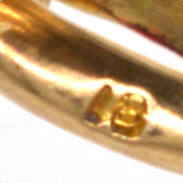 18ct gold hallmark on Edwardian gold locket, ensuring quality and authenticity of the piece.