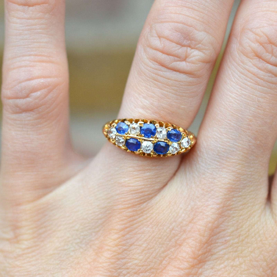 Edwardian 18ct gold chequerboard ring featuring sapphires and old mine cut diamonds, set on a hand.