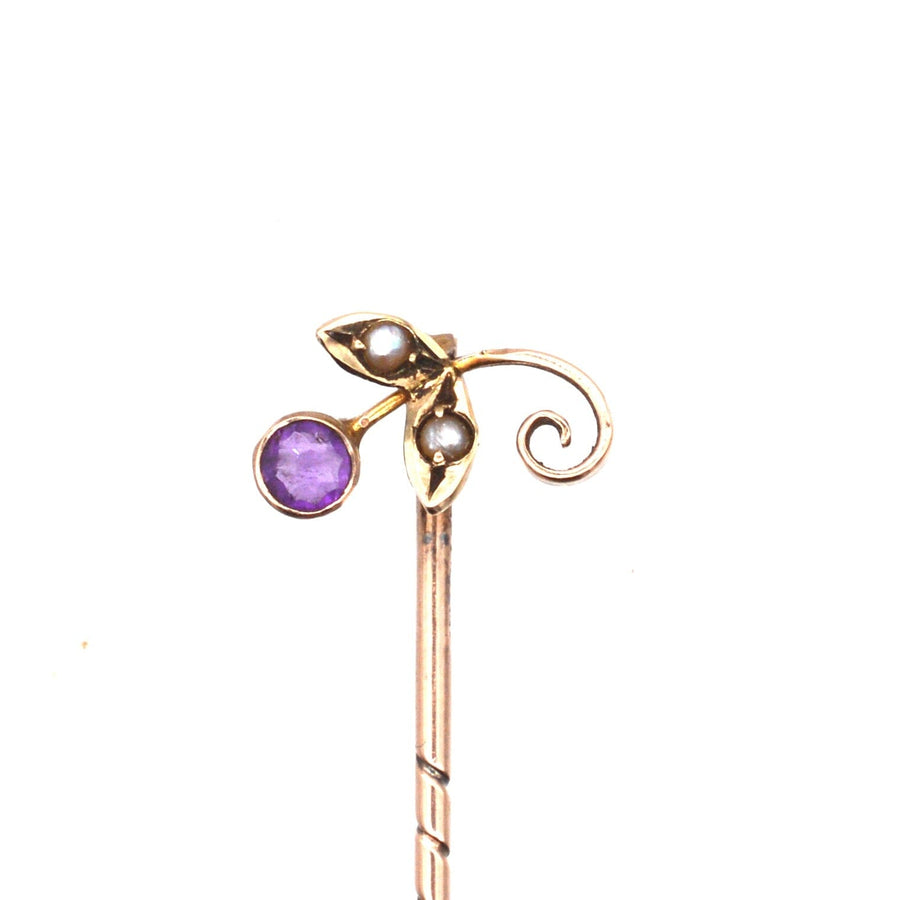 Edwardian 9ct gold tie pin featuring amethyst and seed pearls with decorative floral design.